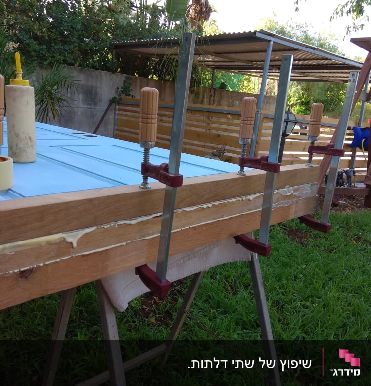 שולחן עבודה עם מהדקים, דבק ועץ בעבודה